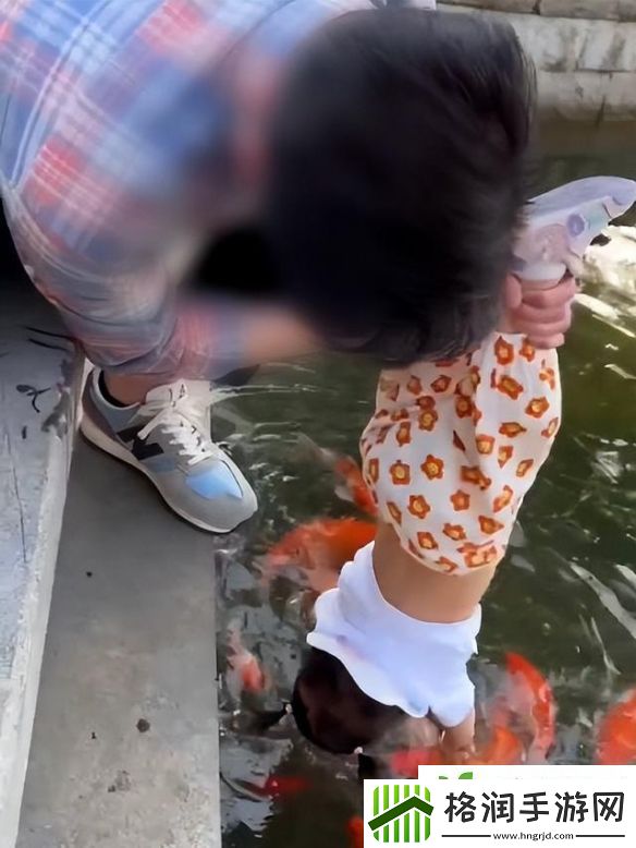 90后宝爸倒提1岁女儿摸金鱼